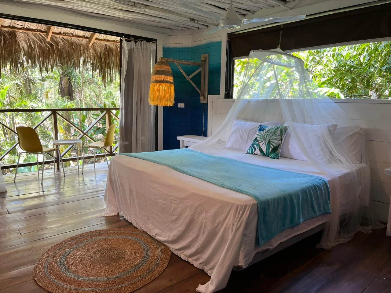 Jungle Loft bedroom with a canopy-draped bed and balcony surrounded by greenery